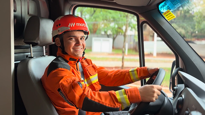 Motorista sentado ao volante dentro de viatura equipado com uniforme Motiva.