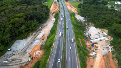 Vista aérea de rodovia Presidente Dutra (BR-116) cercada por áreas de obras e máquinas de construção ao lado da pista.