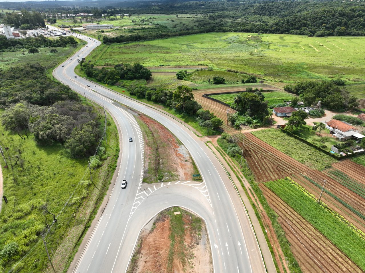 Perspectiva aérea de uma rodovia em meio à floresta.
