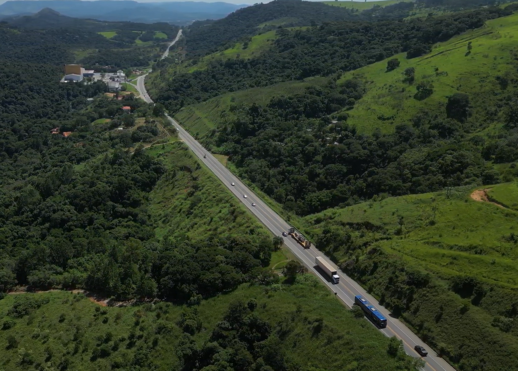 Perspectiva aérea de uma rodovivia em meio à floresta.