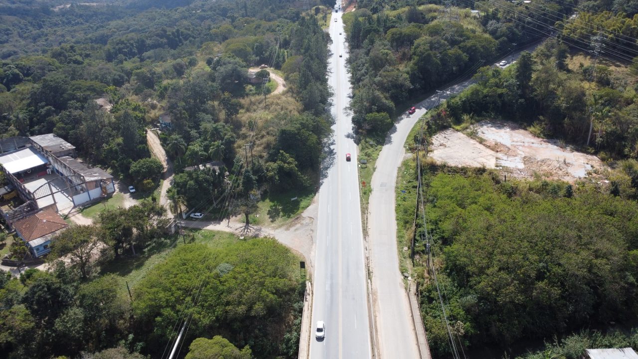 Equipamento de construção em uma estrada de terra próximo a uma floresta, evidenciando a atividade de obras. 