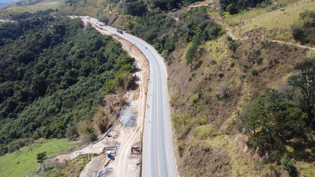 Perspectiva aérea de uma rodovia em meio à floresta.