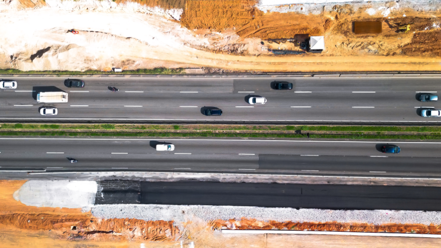 Vista aérea de rodovia em operação com obras de pista marginal ao lado.