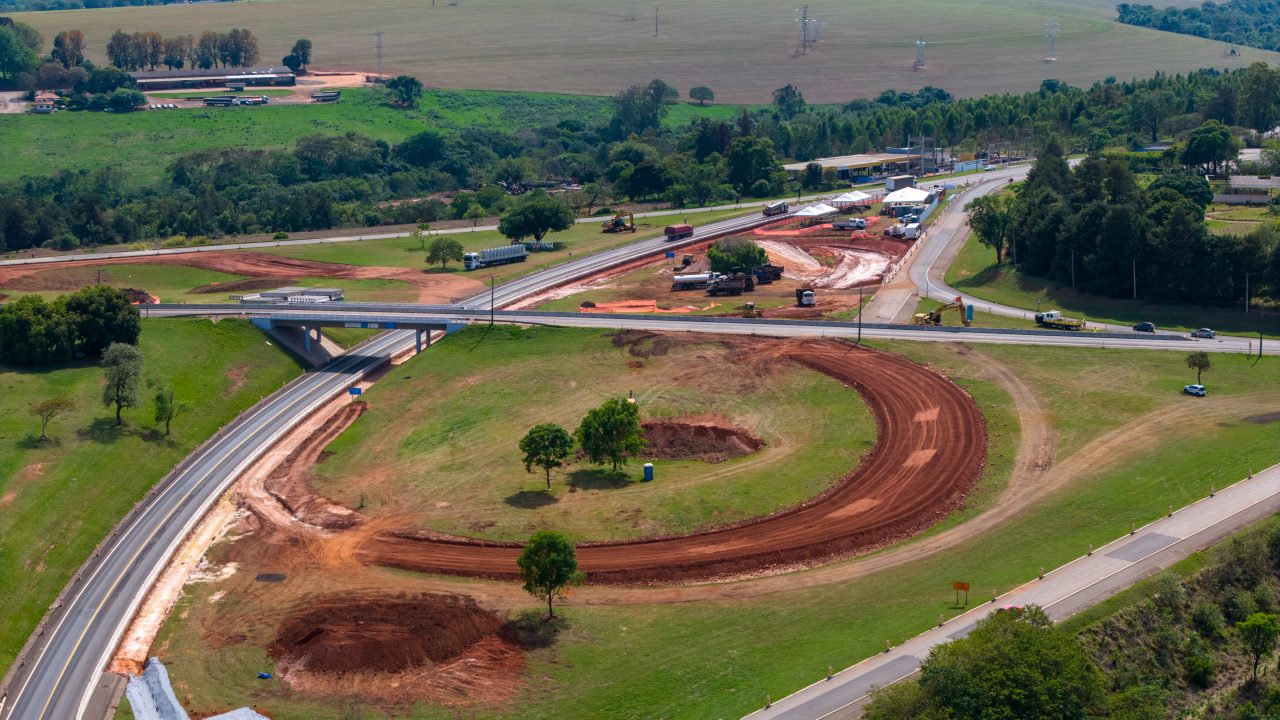 Perspectiva aérea de uma rodovivia em meio à floresta.