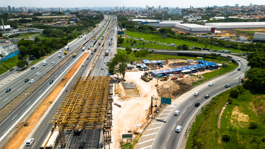 Vista aérea da Via Dutra, na Região Metropolitana de São Paulo, com obras e canteiro de apoio ao lado da rodovia.