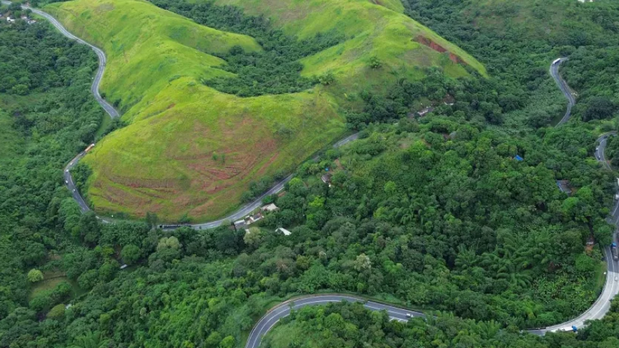 Perspectiva aérea de uma rodovivia em meio à floresta.