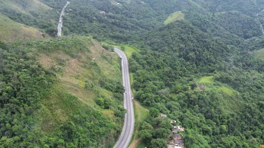 Perspectiva aérea de uma rodovivia em meio à floresta.