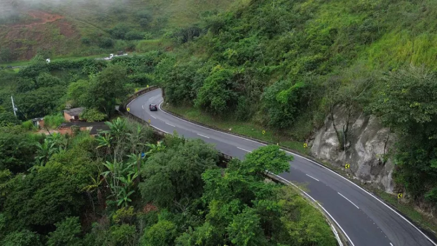 Perspectiva aérea de uma rodovivia em meio à floresta.