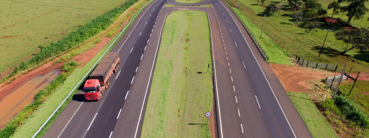 Rodovia de mão dupla, administrada pela CCR MSVia, com vegetação ao longo de suas margens.