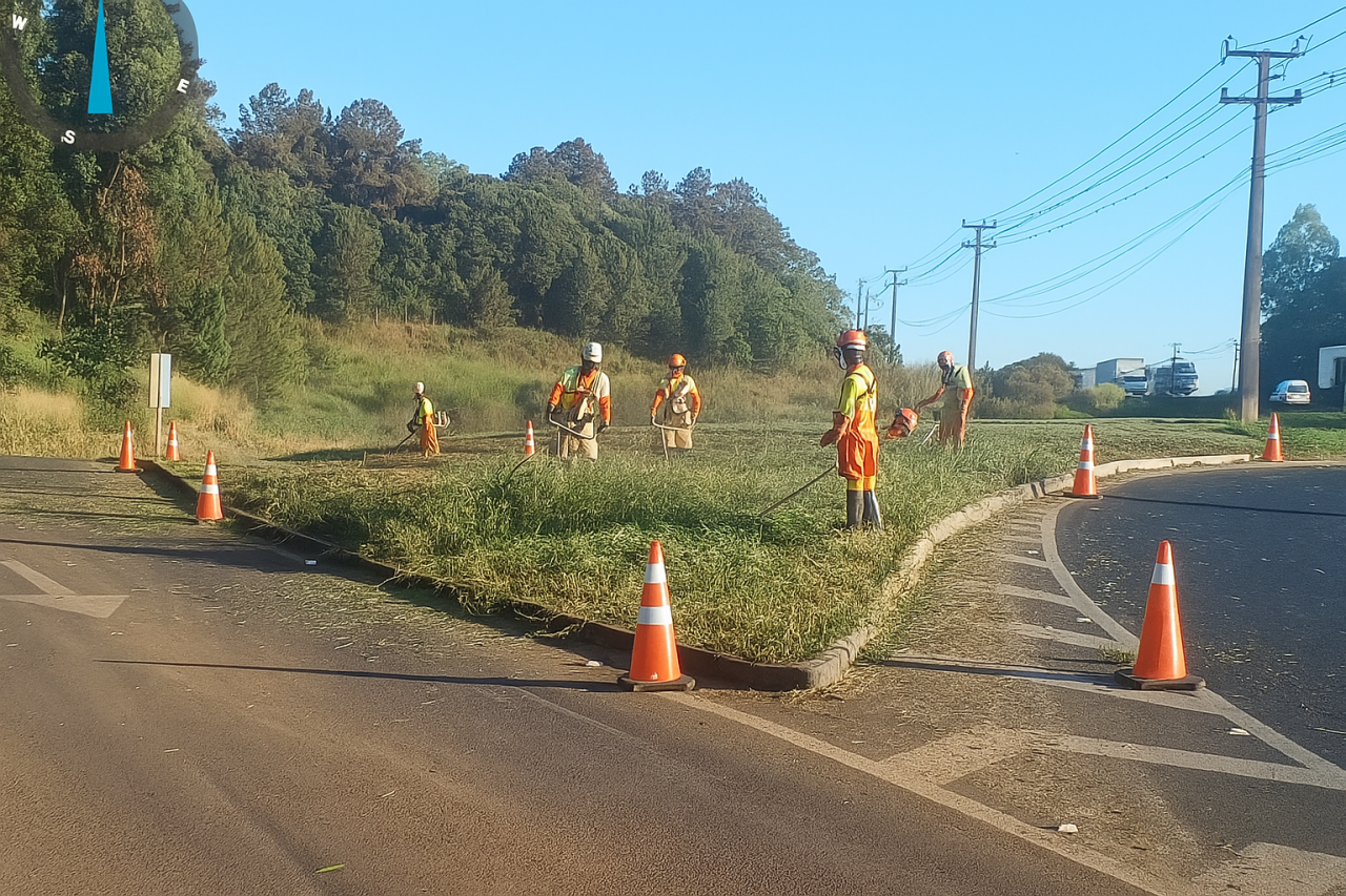 Colaboradores cortam gramado às margens da BR-376, em Ponta Grossa