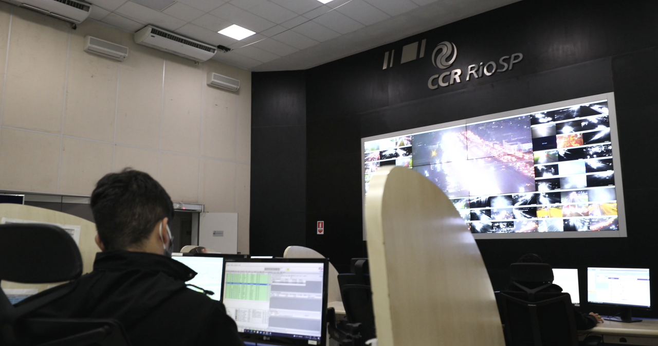 Centro de Controle Operacional da CCR Rio SP, com monitores na parede exibindo imagens das rodovias em tempo real