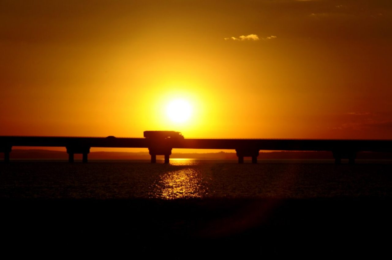 Pôr do sol visto em direção à ponte Rio-Niterói, administrada pela CCR SPVias.
