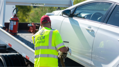 Agente da CCR Via Sul engatando um carro no guincho para reboque.